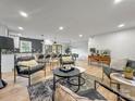Spacious living room featuring an open layout with hardwood floors and modern black leather furniture set on a decorative rug at 3317 Sargeant Dr, Charlotte, NC 28217