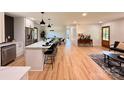 Bright, open-concept floor plan showcasing hardwood floors, white cabinets, an island, and modern lighting at 3317 Sargeant Dr, Charlotte, NC 28217