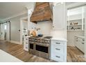Modern kitchen showcasing stainless steel appliances, custom range hood and white cabinetry at 365 Delburg St, Davidson, NC 28036