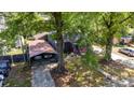 An aerial view showcases this single-story house, a detached carport, mature trees, and a well-maintained front yard at 3919 Sarah Dr # 14, Charlotte, NC 28217