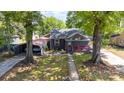 Charming single-story home featuring a screened-in porch, a detached carport, mature trees, and sidewalk leading to front door at 3919 Sarah Dr # 14, Charlotte, NC 28217