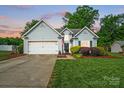 Charming single-Gathering home featuring a two-car garage, well-maintained lawn, and traditional siding at dusk at 503 Azure Ave, Albemarle, NC 28001