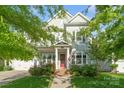 Charming two-story home featuring a red front door, manicured lawn, and an inviting porch with an American flag at 5301 Meadowcroft Way, Fort Mill, SC 29708