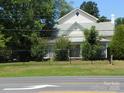Exterior home view featuring a well-manicured lawn and a charming fence along the roadside at 6000 S Main St, Salisbury, NC 28147