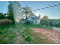 Exterior view of home with overgrown lawn, trees and dirt drive at 6000 S Main St, Salisbury, NC 28147
