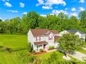 Aerial view of the house featuring manicured lawns, mature trees, and a two-car garage in a serene setting at 6222 Ohaus Ct # 59, Charlotte, NC 28216