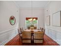 Formal dining room featuring a long wooden table, hardwood floors, and modern décor at 642 Vega Nw St, Concord, NC 28027