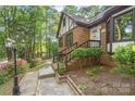 Brick home with front entrance, garden bed and retaining wall with mature plantings at 6617 Wannamaker Ln, Charlotte, NC 28226