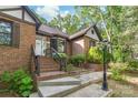 Charming brick home featuring a welcoming front entrance with brick steps and landscaping at 6617 Wannamaker Ln, Charlotte, NC 28226