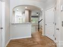 Open-concept foyer featuring wood floors, arched doorways, and staircase to the second floor at 749 Petersburg Dr, Fort Mill, SC 29708