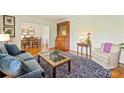 Comfortable living room with hardwood floors, view into dining room, a classic secretary, and a cozy blue sofa at 751 Lansdowne Rd, Charlotte, NC 28270