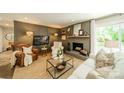 Comfortable living room with fireplace, TV, leather chair, and natural light at 8330 Fallsdale Dr, Charlotte, NC 28214