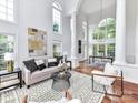 Spacious living room featuring high ceilings, large arched windows, and stylish decor, creating an open and airy feel at 8921 Magnolia Heights Ct, Charlotte, NC 28270