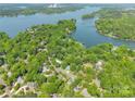 Breathtaking aerial view showcasing a waterfront community nestled among mature trees and a tranquil lake at 9012 Windjammer Dr, Tega Cay, SC 29708