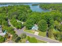 Stunning aerial view of a lakeside home surrounded by lush greenery and serene waters at 9012 Windjammer Dr, Tega Cay, SC 29708