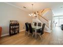Dining room with glass table, modern chairs, liquor cabinet and open staircase at 984 Park Slope Dr, Charlotte, NC 28209