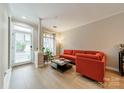 Bright living room with modern orange sofa, hardwood floors, and a large window for natural light at 984 Park Slope Dr, Charlotte, NC 28209