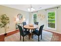 Bright dining room with wood floors, modern lighting, round table, and serene outdoor views at 104 Aurora Ln, Huntersville, NC 28078