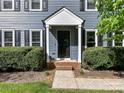 Close up of the front entrance with a black front door, brick steps and manicured hedges at 104 Aurora Ln, Huntersville, NC 28078