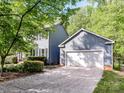 View of the home and detached garage with white doors and blue siding at 104 Aurora Ln, Huntersville, NC 28078