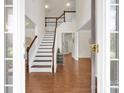 Elegant foyer with hardwood floors, a staircase, and natural light creating a welcoming entrance to the home at 105 Runningdeer Dr, Mooresville, NC 28117
