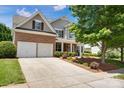 Two-story home with a two-car garage and well-kept lawn with an inviting driveway and walkway at 105 Runningdeer Dr, Mooresville, NC 28117