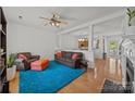 Cozy living room with hardwood floors, ceiling fan, and bright turquoise rug at 11139 Dundarrach Ln, Charlotte, NC 28277
