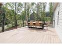 Inviting back deck with sleek railing and outdoor dining set surrounded by trees at 1123 Fern Hill Rd, Mooresville, NC 28117