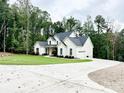 A view of the home's exterior and long driveway, surrounded by mature trees at 1123 Fern Hill Rd, Mooresville, NC 28117