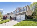 Two-story home with stone accents, siding, two-car garage, and well-maintained lawn at 117 Tom Sawyer Ln, Mount Holly, NC 28120