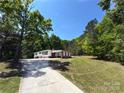Quaint single-story home nestled among mature trees, featuring a long driveway and well-manicured lawn at 12719 Cottonville Rd, Norwood, NC 28128