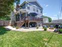 Expansive backyard featuring a deck, outdoor seating, a fire pit, and well-maintained lawn at 1421 Lyon Ct, Charlotte, NC 28205