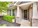 Charming front entrance with a decorated door, brick facade, and manicured bushes at 1446 Cilantro Ct, Tega Cay, SC 29708