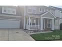 Charming home with two-car garage, inviting porch with white railing, and lush lawn at 15326 Carrington Ridge Dr, Huntersville, NC 28078
