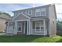 Two-story house featuring a welcoming front porch with white columns and a well-manicured lawn at 15326 Carrington Ridge Dr, Huntersville, NC 28078