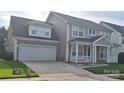 Inviting two-story home with a two-car garage, a quaint front porch, and meticulous landscaping at 15326 Carrington Ridge Dr, Huntersville, NC 28078