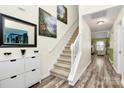 Bright hallway featuring stylish flooring, carpeted stairs, and decorative artwork adding character to the home at 2110 Cool Springs Ct, Kannapolis, NC 28083