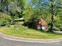 Brick two-story home with attached garage and a well-manicured lawn and garden at 3100 Ventosa Dr, Charlotte, NC 28205
