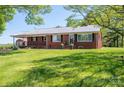 Brick home with a metal roof and front yard with green grass at 3340 Wrenwood Dr, Newton, NC 28658