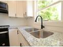 Close up on the kitchen with stainless steel sink, gooseneck faucet, and granite countertops at 406 W Marion St, Kershaw, SC 29067