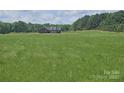 Picturesque home with lush green lawn and tree line, offering a serene and private setting at 485 Hilltop Rd, Oakboro, NC 28129