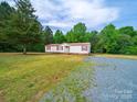 Pristine single story home with rock driveway and wooded backdrop at 5318 Austin Rd, Monroe, NC 28112
