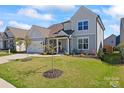 Charming two-story home with a well-manicured lawn, attached garage, and covered front porch at 6159 Holland St, Fort Mill, SC 29707