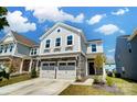 Inviting two-story home with stone accents, attached two-car garage, and manicured front yard with blue sky at 637 Scotch Meadows Loop, Monroe, NC 28110