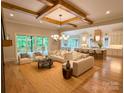 Bright open-concept living room with wood beams, hardwood floors, and seamless flow to kitchen and outdoor deck at 724 Ideal Way, Charlotte, NC 28203