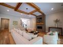 Comfortable living room with fireplace, hardwood floors, wood beam ceiling, and access to the staircase at 724 Ideal Way, Charlotte, NC 28203