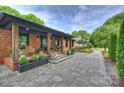 Inviting brick home porch featuring stone pavers, wood columns, and stylish decor at 742 Lansdowne Rd, Charlotte, NC 28270