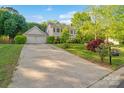 Beautifully landscaped home with a long driveway leading to a two-car garage at 9100 Cameron Wood Dr, Charlotte, NC 28210