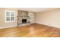 Inviting living room featuring a stone fireplace, hardwood floors, and bright windows at 1000 Rudd Rd, Gastonia, NC 28054