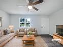 Bright living room features a ceiling fan and natural light; is virtually staged with contemporary furniture at 109 Downing St, Troutman, NC 28166